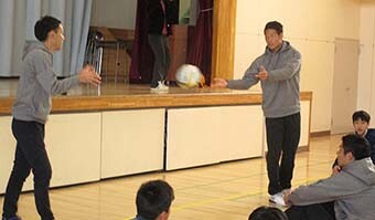 Image: Kazushi Hano and Harunori Tsuruya showing the class how to handle the ball