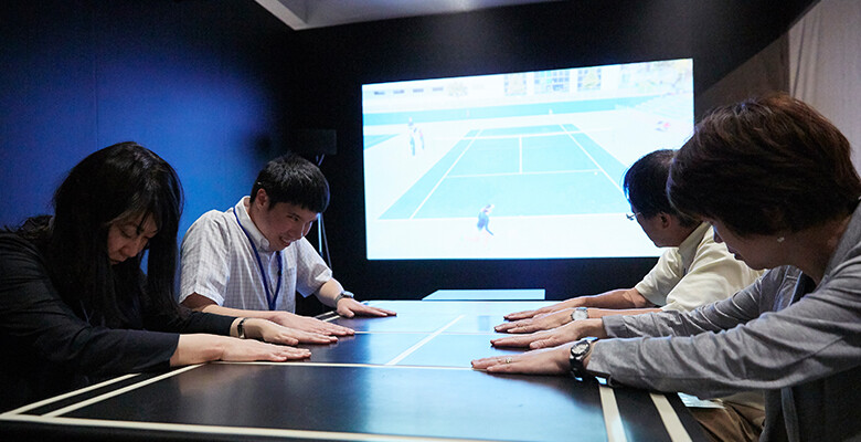 Image：Demonstration participants viewing a tennis match by feeling vibrations.