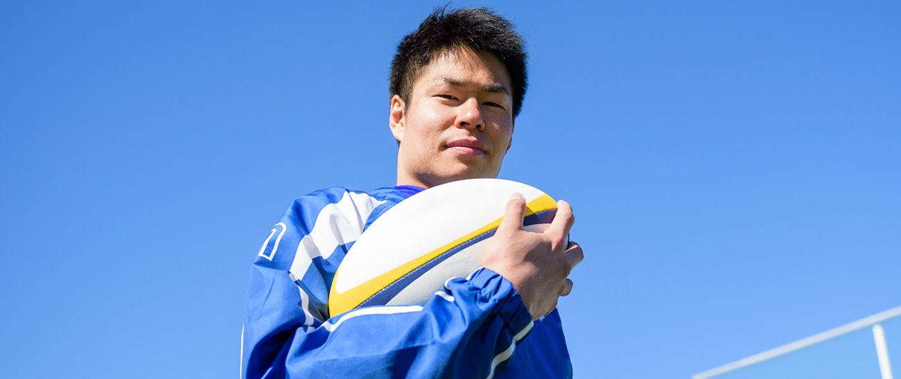 Image: Photograph of Kazushi Hano holding a football.