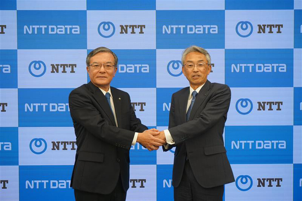 写真：NTT 島田明 代表取締役社長とNTTデータグループ 佐々木裕 代表取締役社長が握手する様子