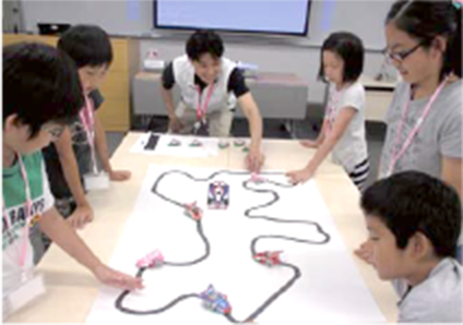 写真：プログラミング入門　NTTデータアカデミアで、プログラミングを教える先生と授業を受ける子どもたちの様子