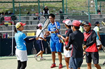 写真：NTT西日本ソフトテニス部によるふれあいソフトテニス教室で、コートで選手から説明を受ける子どもたちの様子