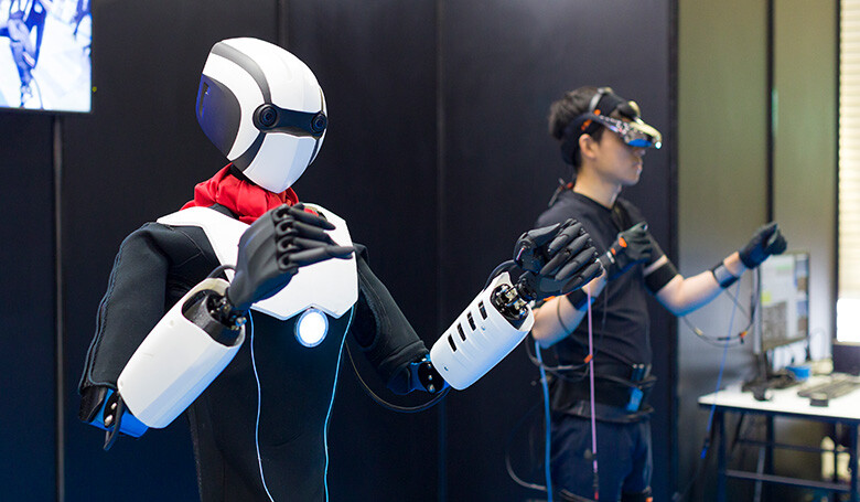 Image: Photograph of a man and robot synchronizing using the 