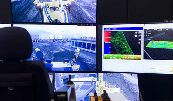 Image: Photograph of multiple monitors displaying a remote control system for construction equipment.