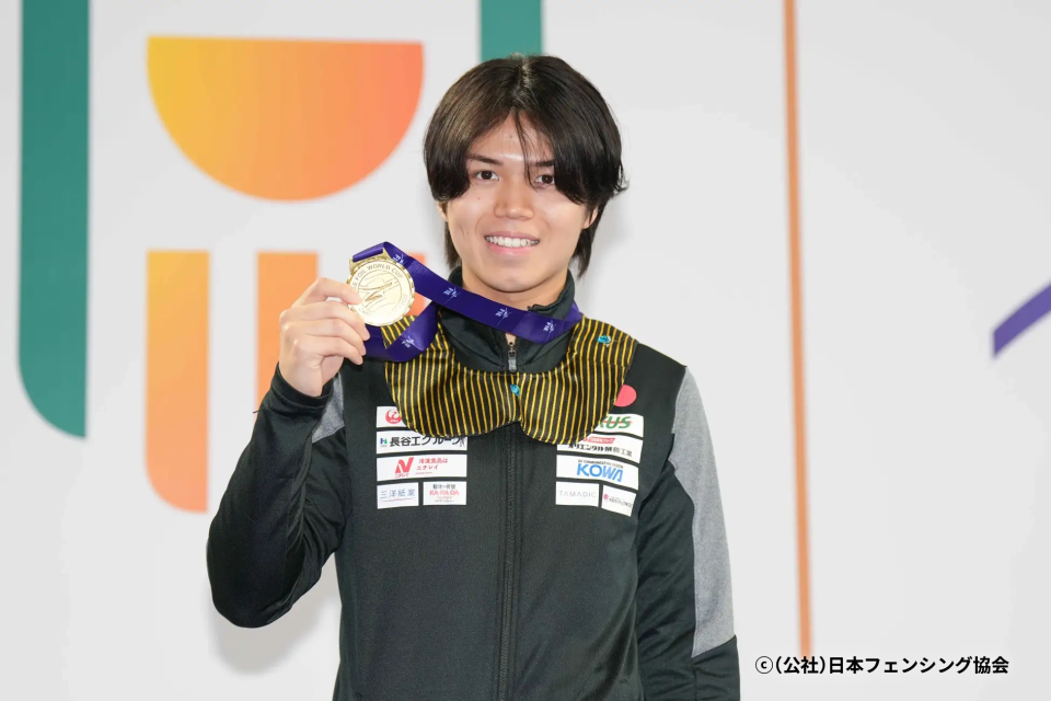 写真：メダルを掲げる飯村 一輝選手 ⓒ（公社）日本フェンシング協会